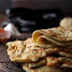 These soft keto tortillas are folded in half over a stack of other low carb tortillas.